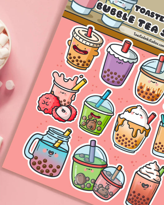 Close-up of a Toastedink Bubble Tea Sticker Sheet with cute characters including green matcha boba, lychee tea, caramel whipped tea and a mason jar boba. A pastel pink background complements the kawaii theme. Sold by Rebel Romance.