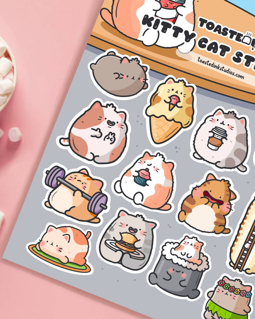 Close-up of the Toastedink Kitty Cat Sticker Sheet sold by Rebel Romance. Showcases cute illustrated cats in various funny forms like sushi, hula cat, ice cream and more. Great for decorating journals and diaries.