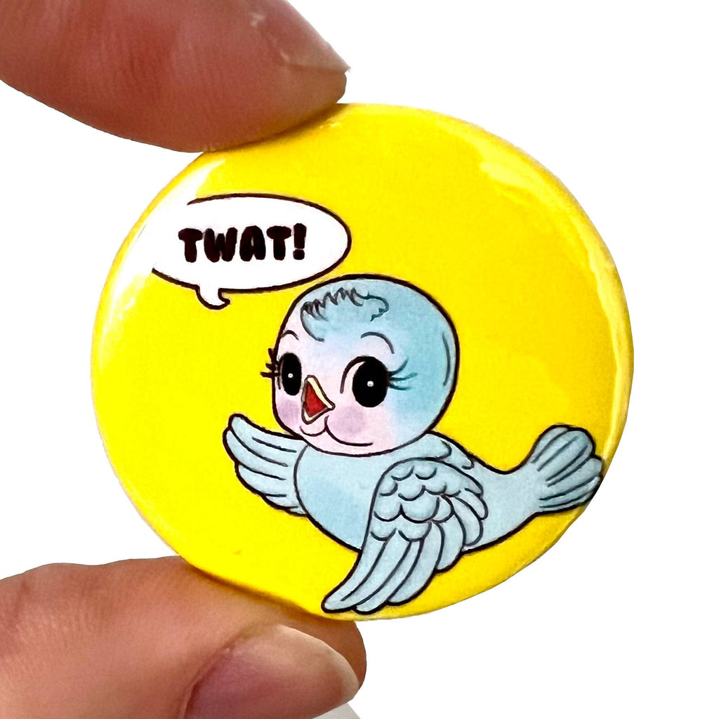A 38mm glossy pin badge featuring a retro-style bluebird illustration with a cheeky speech bubble saying “Twat” on a bright yellow background. A playful, kitschy accessory designed to add humour and personality.