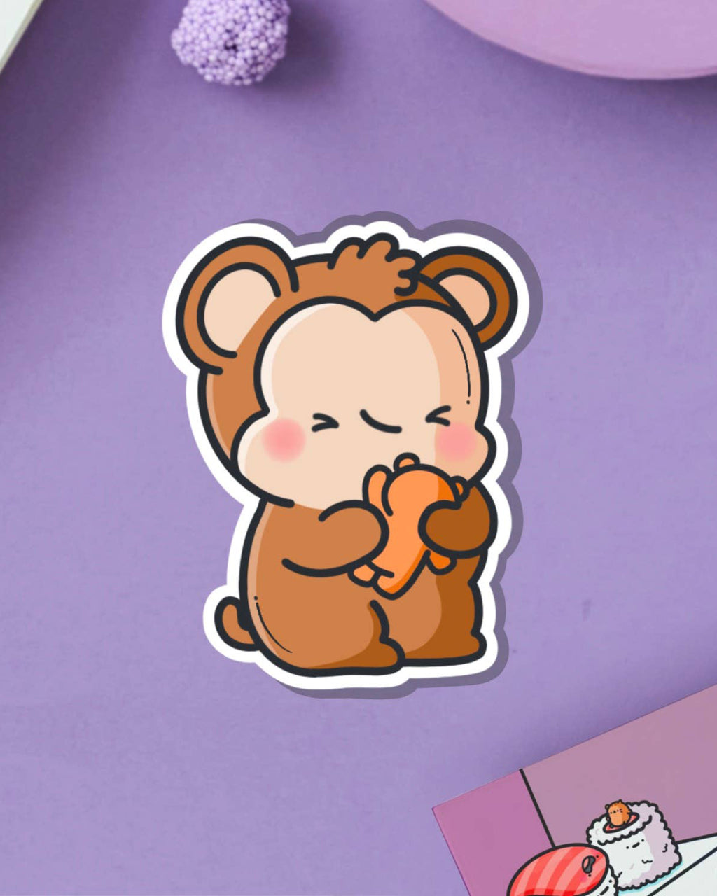 Adorable monkey and teddy bear vinyl sticker by Toastedink, shown on a lilac purple backdrop with decorative props. Available from Rebel Romance, a UK-based small biz for alternative fashion and retro-inspired accessories.