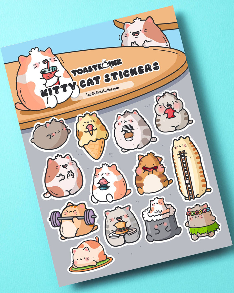 Toastedink Kitty Cat Sticker Sheet on a blue background. Includes adorable cartoon cats dressed as ice cream, lifting weights, lounging and munching burgers. A fun and quirky stationery gift from Rebel Romance.