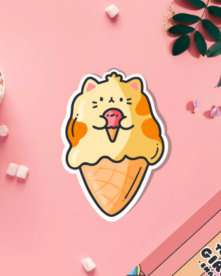 Funny cat ice cream cone vinyl sticker by Toastedink on a pink background, surrounded by marshmallows, flower petals, and green leaves.
