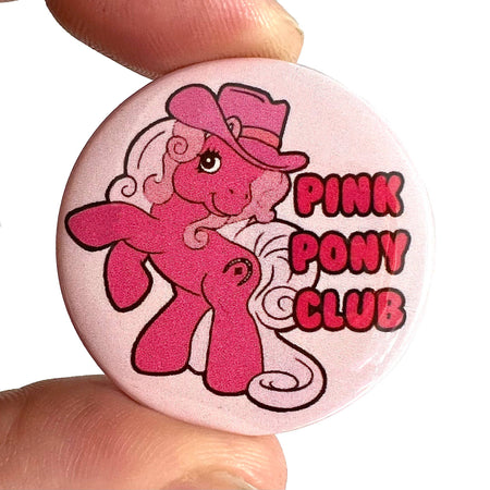 A high-gloss 38mm button pin badge featuring a pink pony with a cowboy hat and curly mane, alongside the text “Pink Pony Club” in bold red lettering. A fun pop culture-inspired accessory designed by Bite Your Granny.