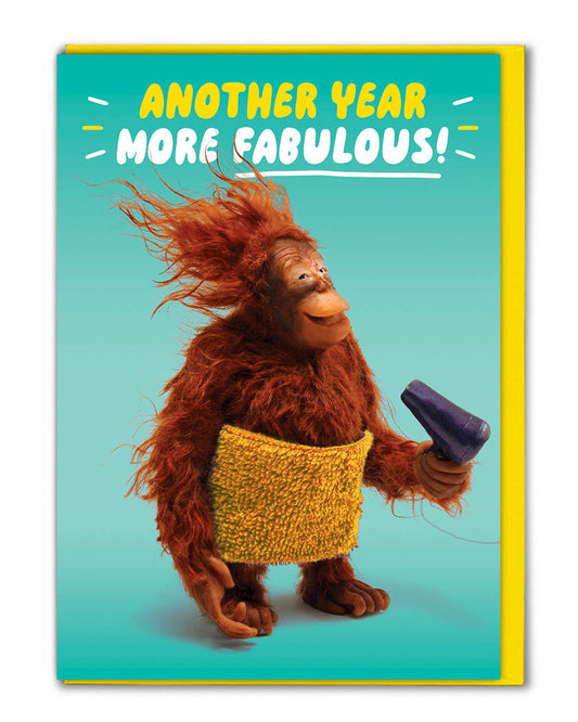 Rebel Romance Orangutan Another Year More Fabulous Funny Birthday Card. A quirky greeting card featuring a cheerful orangutan wrapped in a yellow towel, holding a hairdryer with windswept hair against a turquoise background. Caption reads “Another Year More Fabulous!” A playful, humorous birthday card printed in the UK, blank inside with envelope included. Perfect for millennials who love unique and alternative cards.