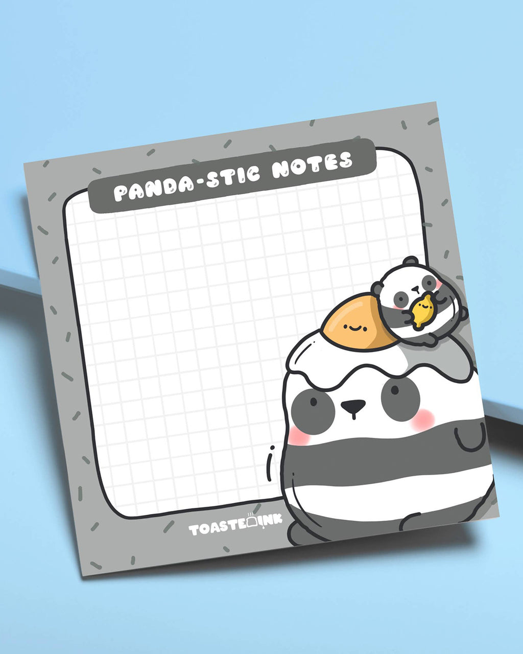 Flat lay of Toastedink's Panda-stic Notes sticky pad on a blue background. Featuring a chubby panda with a sunny-side-up egg and baby panda chick, available at Rebel Romance – a UK small biz for millennial magic lovers.