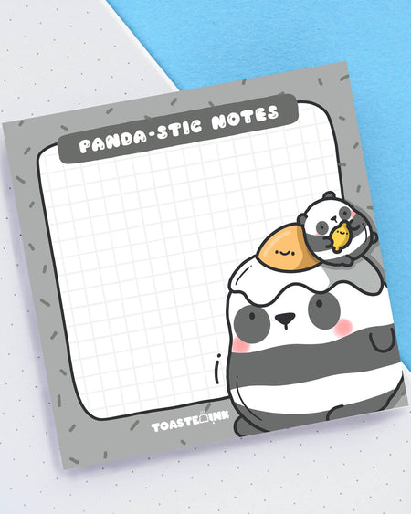 Square sticky note pad featuring a cute panda character with a fried egg and mini panda chick on its head. Grid paper design with "Panda-stic Notes" pun at the top. Stocked by Rebel Romance, a UK-based alternative lifestyle shop.