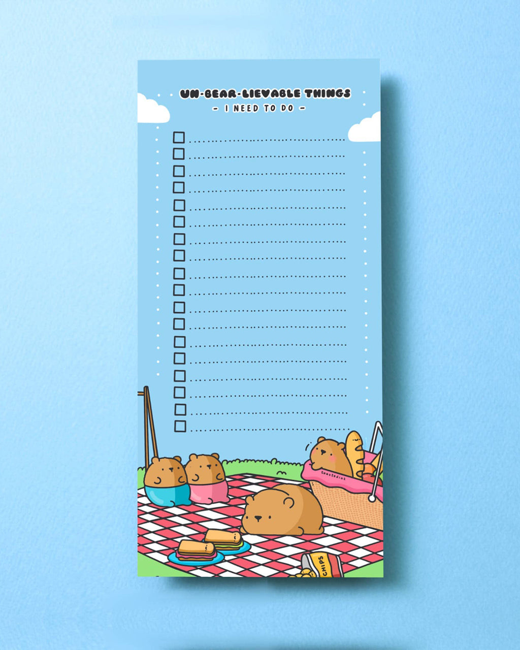 Full view of the Toastedink Un-Bear-Lievable to-do list pad placed on a light blue background. The pad features cheerful bears enjoying a picnic scene, with checkboxes for tasks and a bright, playful design.