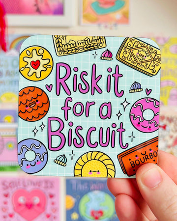 Rebel Romance “Risk It For A Biscuit” coaster by Kelly Lou held in hand, with cute illustrated biscuits like bourbons and custard creams on a blue grid design. A playful homeware gift from a UK small business that celebrates alternative aesthetics and millennial style.