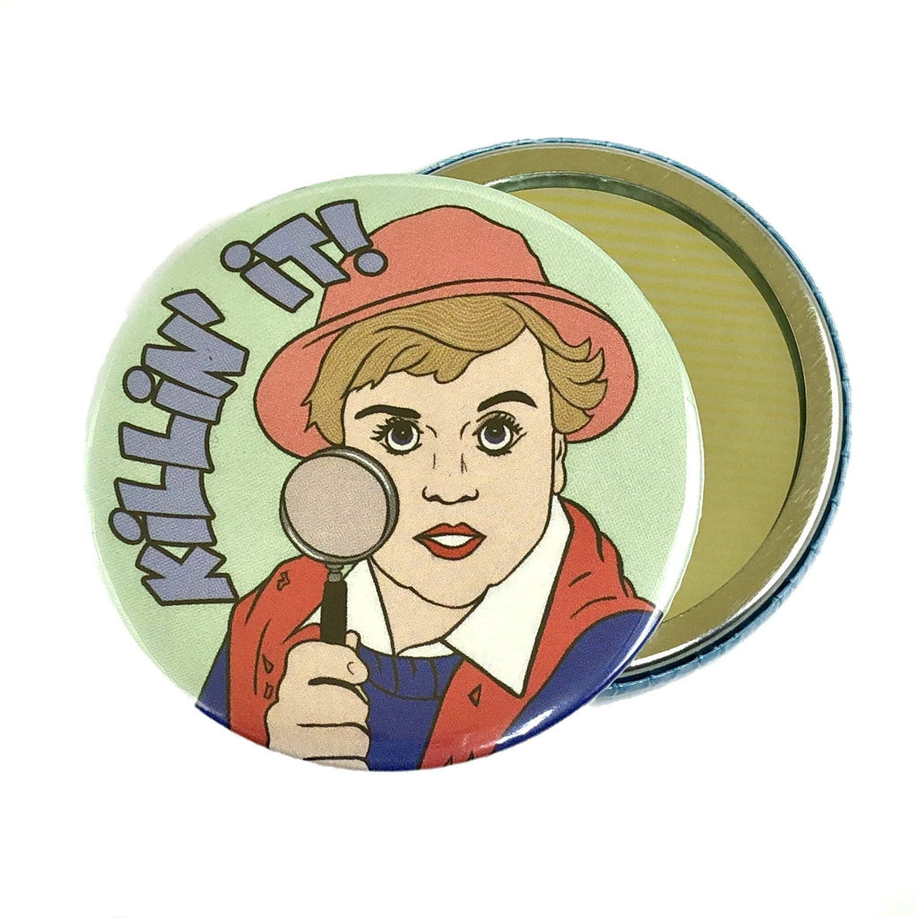 Handheld pocket mirror featuring a cartoon-style illustration inspired by Jessica Fletcher from Murder, She Wrote, holding a magnifying glass with the words “Killin’ it!” in bold retro text. Designed by Bite Your Granny for Rebel Romance, a small UK brand celebrating alternative fashion and quirky gifts for millennials.