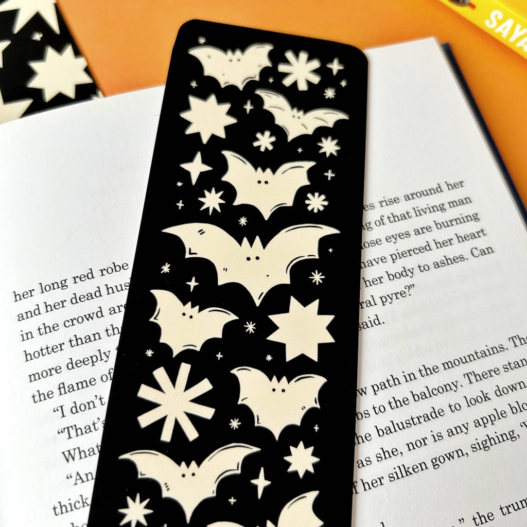 Discover the Bats Bookmark – a gothic Halloween-inspired accessory featuring a spooky bats and stars design by Stacey McEvoy Caunt. Luxurious velvet matte finish, 14.8 x 5.2 cm, and professionally printed in the UK. Perfect for book lovers and spooky season enthusiasts!
