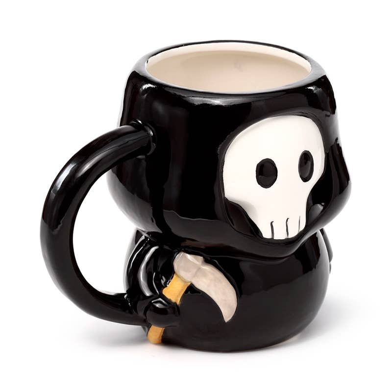 Three-quarter view of the Skull Boy Shaped Mug showing its handle and skull detail while holding a tiny scythe. A gothic ceramic cup from UK brand Rebel Romance, perfect for Halloween lovers.