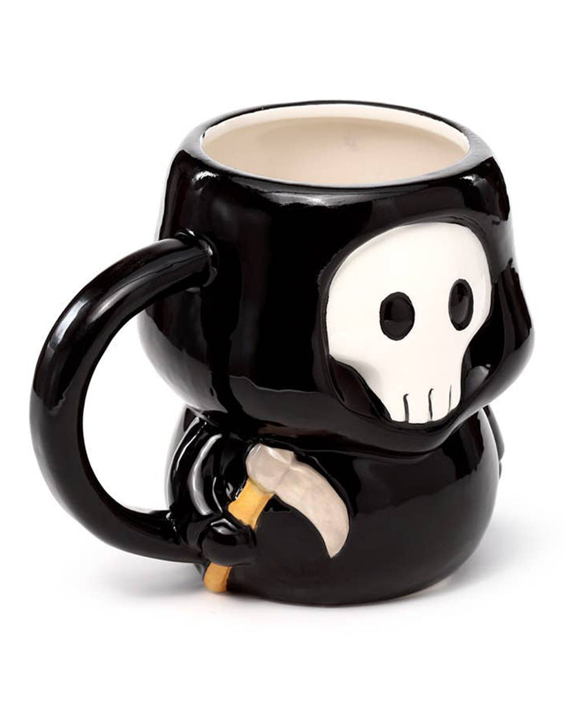 Three-quarter view of the Skull Boy Shaped Mug showing its handle and skull detail while holding a tiny scythe. A gothic ceramic cup from UK brand Rebel Romance, perfect for Halloween lovers.