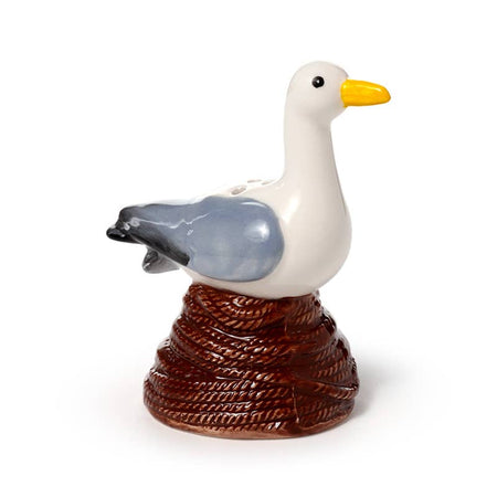 A ceramic salt or pepper shaker shaped like a seagull perched on a coiled rope buoy. Hand-painted in soft grey, white, yellow, and brown tones. A quirky kitchen accessory from Rebel Romance, a UK small business celebrating alternative style.