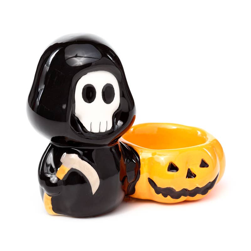 Angled front view of the Ceramic Skull Boy Tea Light Holder with a detailed jack-o'-lantern design. This glossy ceramic candle holder by Rebel Romance adds spooky charm to your shelf, altar or seasonal display.