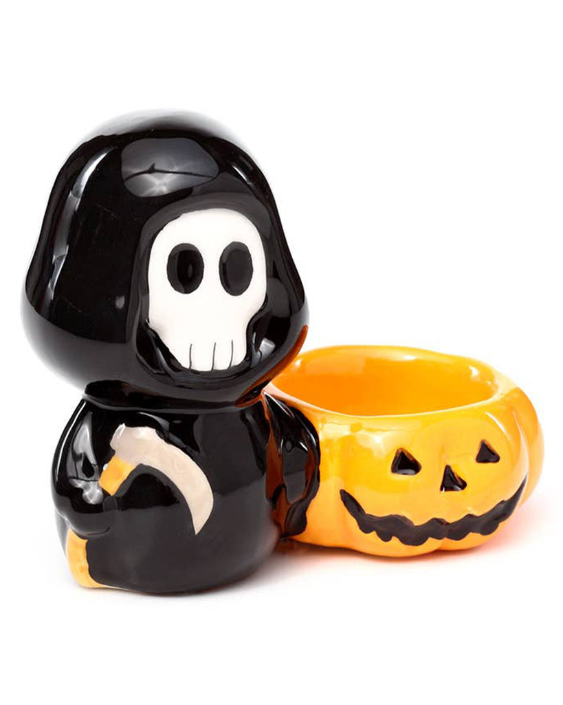 Angled front view of the Ceramic Skull Boy Tea Light Holder with a detailed jack-o'-lantern design. This glossy ceramic candle holder by Rebel Romance adds spooky charm to your shelf, altar or seasonal display.