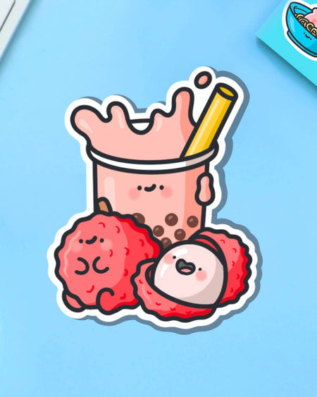 Bright and cheerful lychee bubble tea sticker showing cute characters with boba pearls and lychee fruits. Set on a pastel blue background with yellow flowers, this sticker is part of Rebel Romance's alternative and kawaii stationery collection.