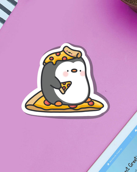 Toastedink’s Pizza Penguin Sticker on a lilac background. A chubby penguin character enjoys pizza while surrounded by it. Glossy and waterproof, this vinyl sticker from Rebel Romance is great for planners and laptops.