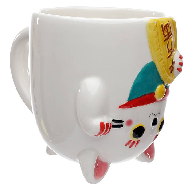 Side view of the upside down maneki neko cat-shaped mug, showing hand-painted details including a red and teal collar and a raised paw. A playful ceramic mug from Rebel Romance, ideal for alternative home décor lovers.