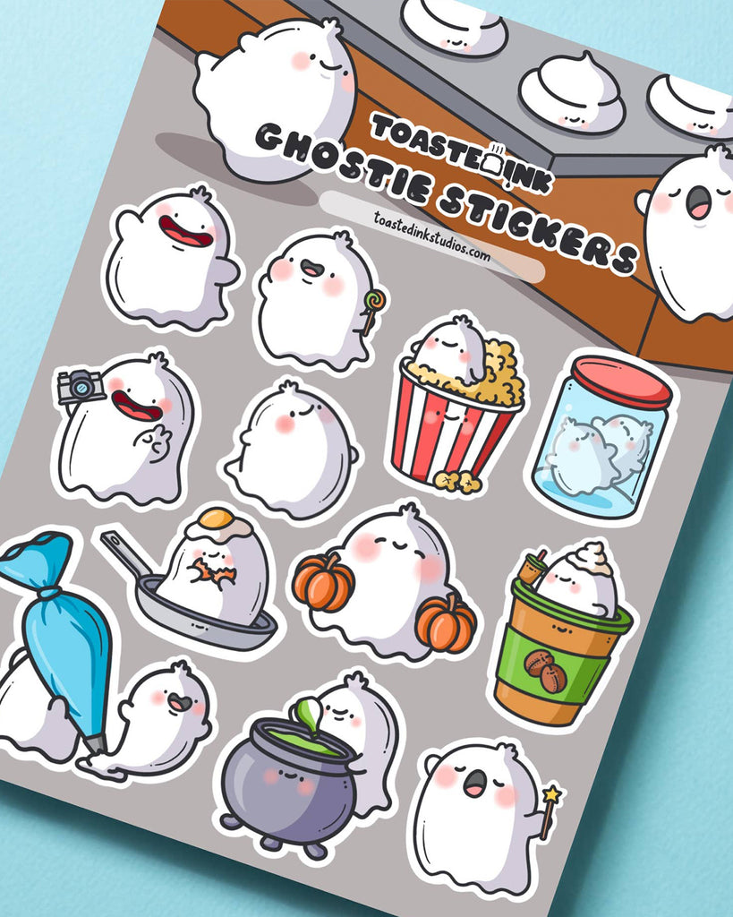 Toastedink’s ghostie sticker sheet on a grey background featuring ghosts in pumpkin patches, cauldrons, and cups. A perfect Halloween-themed stationery treat. Sold by Rebel Romance, the UK’s home of cute, spooky aesthetics.