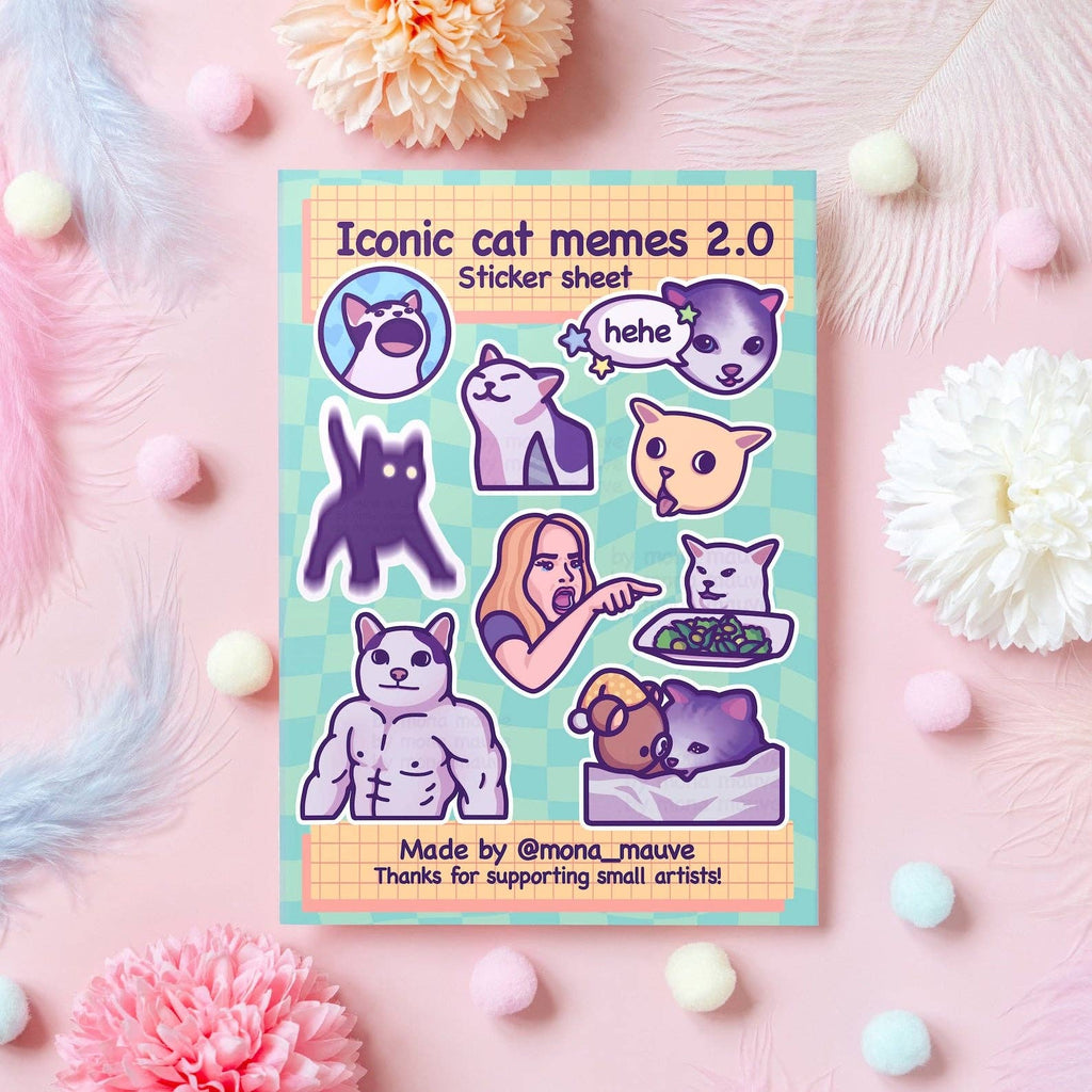 Flat lay of the Iconic Cat Memes 2.0 Sticker Sheet by Mona Mauve, featuring 9 funny vinyl stickers inspired by popular cat internet memes. Includes muscle cat, woman yelling at cat, and “hehe” cat faces. Displayed on a mint green sheet with pastel pompoms and flowers. A playful gift for meme fans and cat lovers.