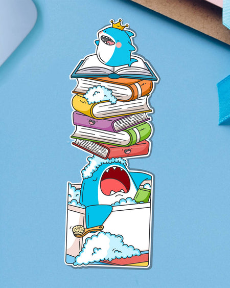 Rebel Romance shark bookmark by Toastedink, featuring a blue shark king in a bubble bath with books on its nose. Displayed on a bright blue background with ribbon detail in the corner.
