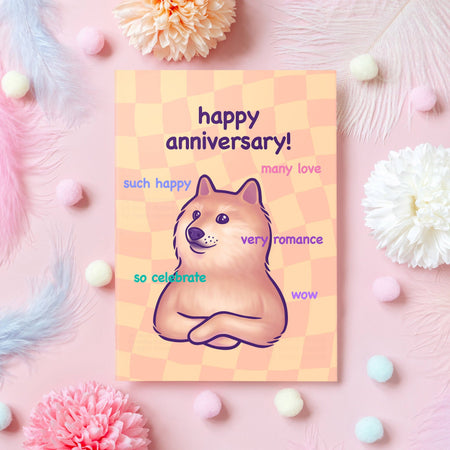 Funny Happy Anniversary card designed by Mona Mauve for Rebel Romance, featuring a Doge-style Shiba Inu on a peach checkerboard background with meme phrases like “very romance” and “so celebrate.” Surrounded by pastel flowers, feathers, and pom poms on a pink surface. A playful and cute card for celebrating love with humour, perfect for meme fans and alternative couples.