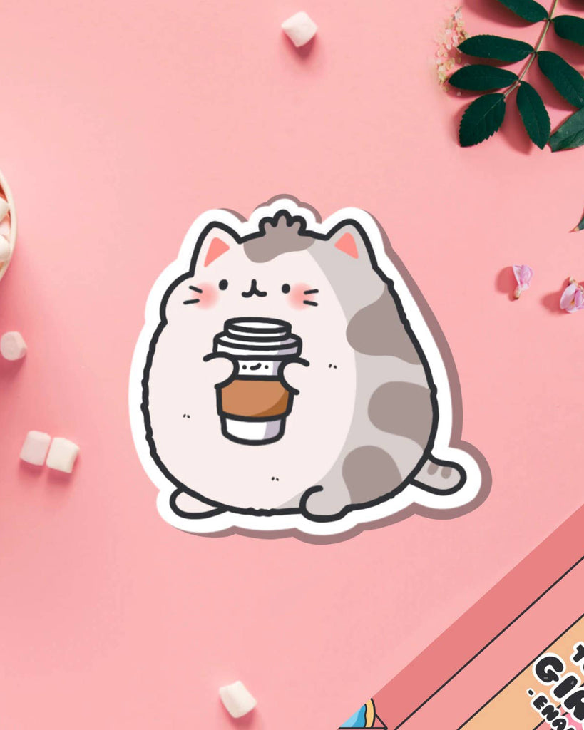 Coffee Cat Vinyl Sticker by Toastedink on a pastel pink background. Features a chubby grey and white cartoon cat holding a takeaway coffee cup with rosy cheeks. Stocked by Rebel Romance, this glossy waterproof sticker is perfect for laptops and water bottles.