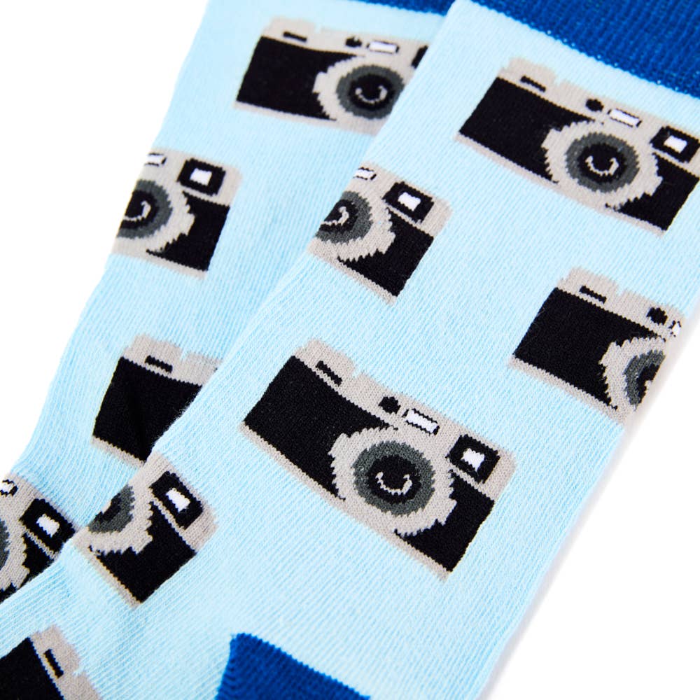 Zoomed-in view of Urban Eccentric novelty socks covered in retro camera graphics on a blue background. Available now at Rebel Romance.