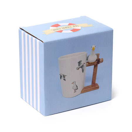 Product packaging for the Seagull Buoy Mug by Rebel Romance. The blue box features a photo of the ceramic mug with its whimsical seagull handle and flying bird illustrations—ideal for gifting seaside lovers or collectors.