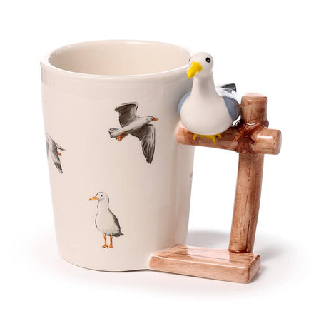 Ceramic mug with flying seagull illustrations and a unique 3D handle shaped like a wooden post with a perched ceramic seagull. Designed by Rebel Romance, a UK brand celebrating quirky, coastal-inspired gifts with a playful twist.