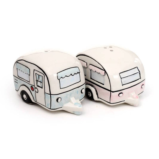 A close-up of the full ceramic salt and pepper set from Rebel Romance. Includes two shakers: a pastel pink caravan and a pastel blue one, each with unique illustrated detailing. A playful, retro-inspired kitchen or campervan accessory.