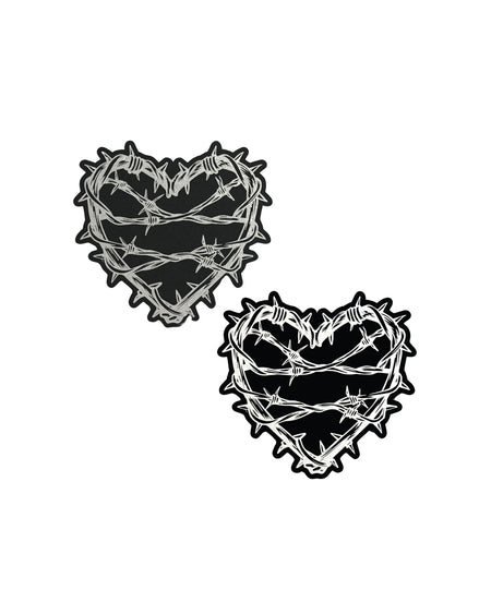 The Barbed Wire Heart Pasties Reflective Nipple Covers by Pastease®. Two black hearts with silver reflective barbed wire patterned shaped nipple covers shown on a white background. Perfect for festivals, pride, burlesque, raves, only fans content or parties.