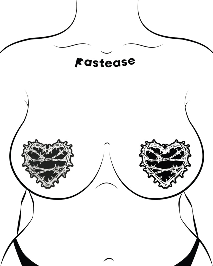 The Barbed Wire Heart Pasties Reflective Nipple Covers by Pastease®. Two black hearts with silver reflective barbed wire patterned shaped nipple covers shown on a femme body outline for size reference on a white background. Perfect for festivals, pride, burlesque, raves, only fans content or parties.