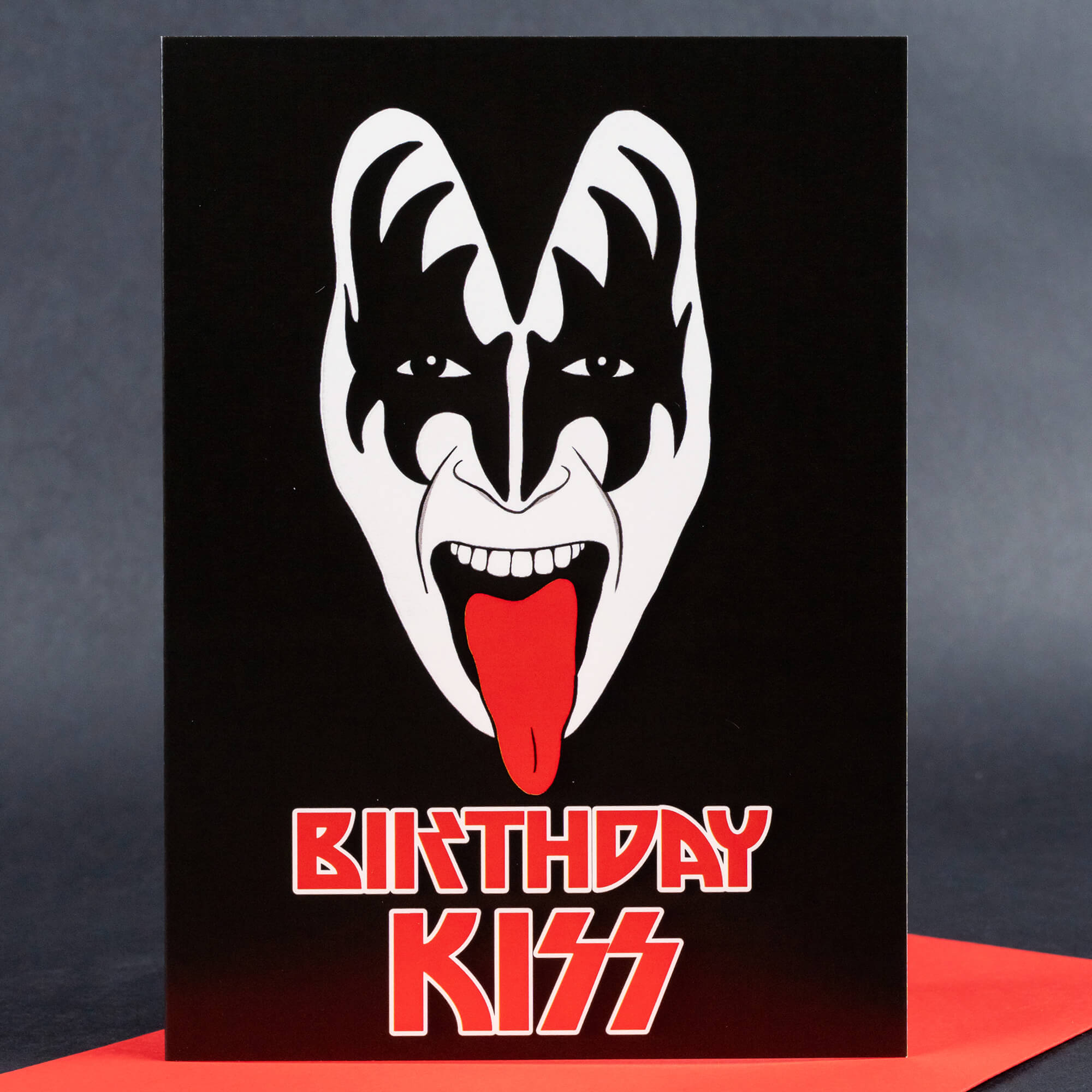 Rock-themed birthday card with a graphic design of Gene Simmons-inspired face paint and text ‘BIRTHDAY KISS’ in red rock font against a black background.
