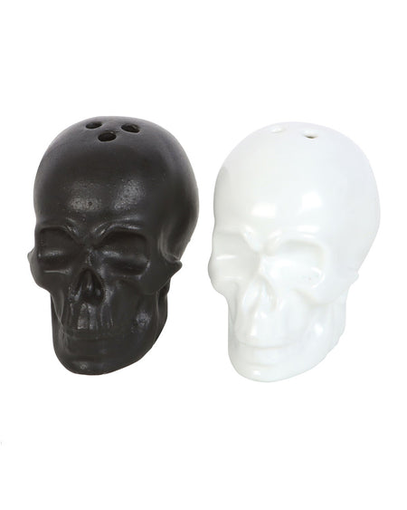 Black and white ceramic skull salt and pepper shakers placed side by side.