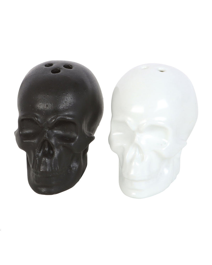 Black and white ceramic skull salt and pepper shakers placed side by side.