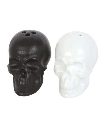 Black and white ceramic skull salt and pepper shakers placed side by side.