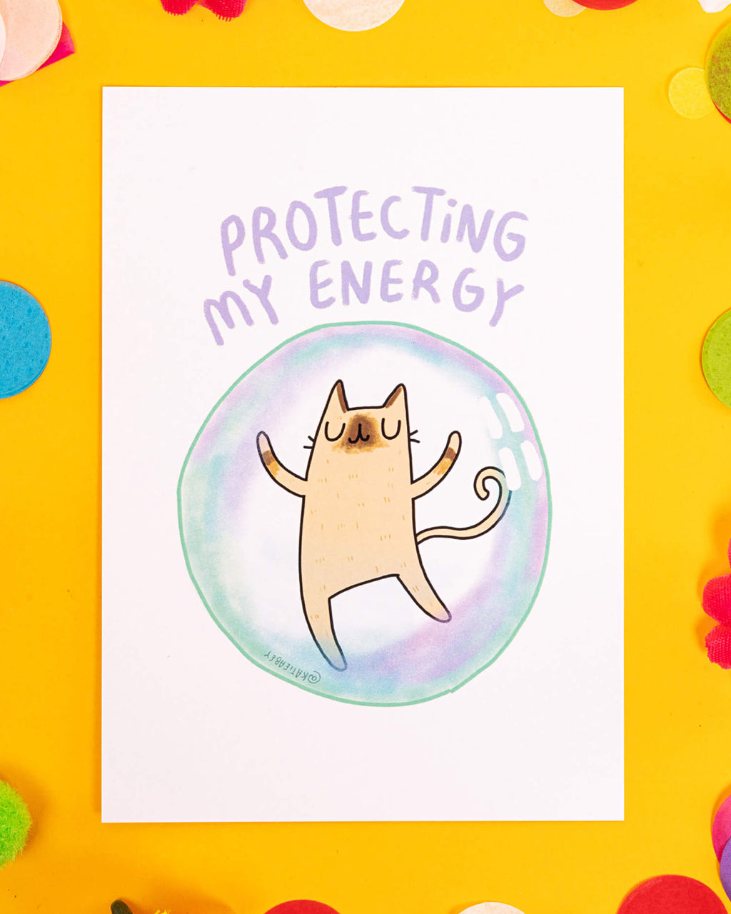 A white A6 postcard featuring a calm cartoon cat floating inside a pastel rainbow bubble, with the words “Protecting My Energy” above it in soft purple lettering. Illustrated by Katie Abey, this quirky and soothing postcard is perfect for alternative stationery lovers, millennials into mindfulness, and those embracing slow living or dopamine decor.