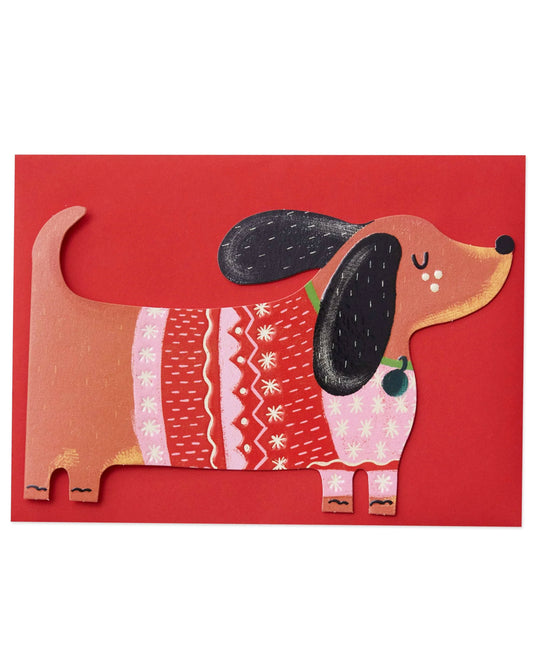 Dachshund Christmas card featuring a cute sausage dog in a red and pink festive jumper with snowflake patterns. The die-cut card is finished with embossing and spot UV gloss for a tactile effect, perfect for dog lovers this Christmas.