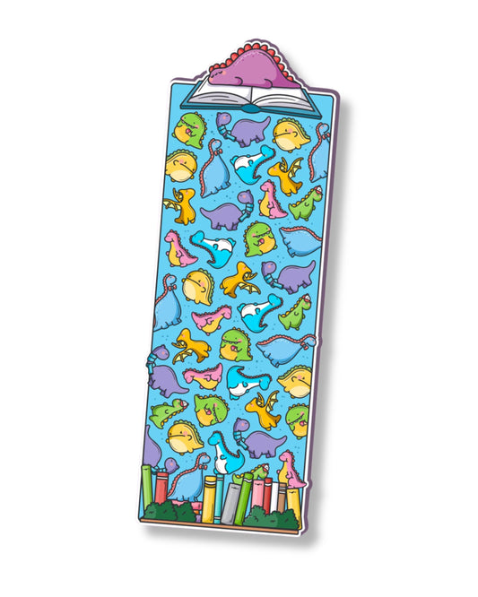 Cute dinosaur bookmark by Toastedink, sold by Rebel Romance, featuring colourful cartoon dinosaurs scattered across a blue background, with a pink dinosaur