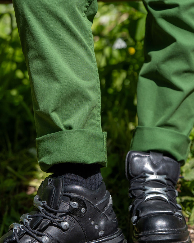Cuffed leg detail of the Forest Green Stretch Twill Dungarees styled with chunky black boots, photographed outdoors.