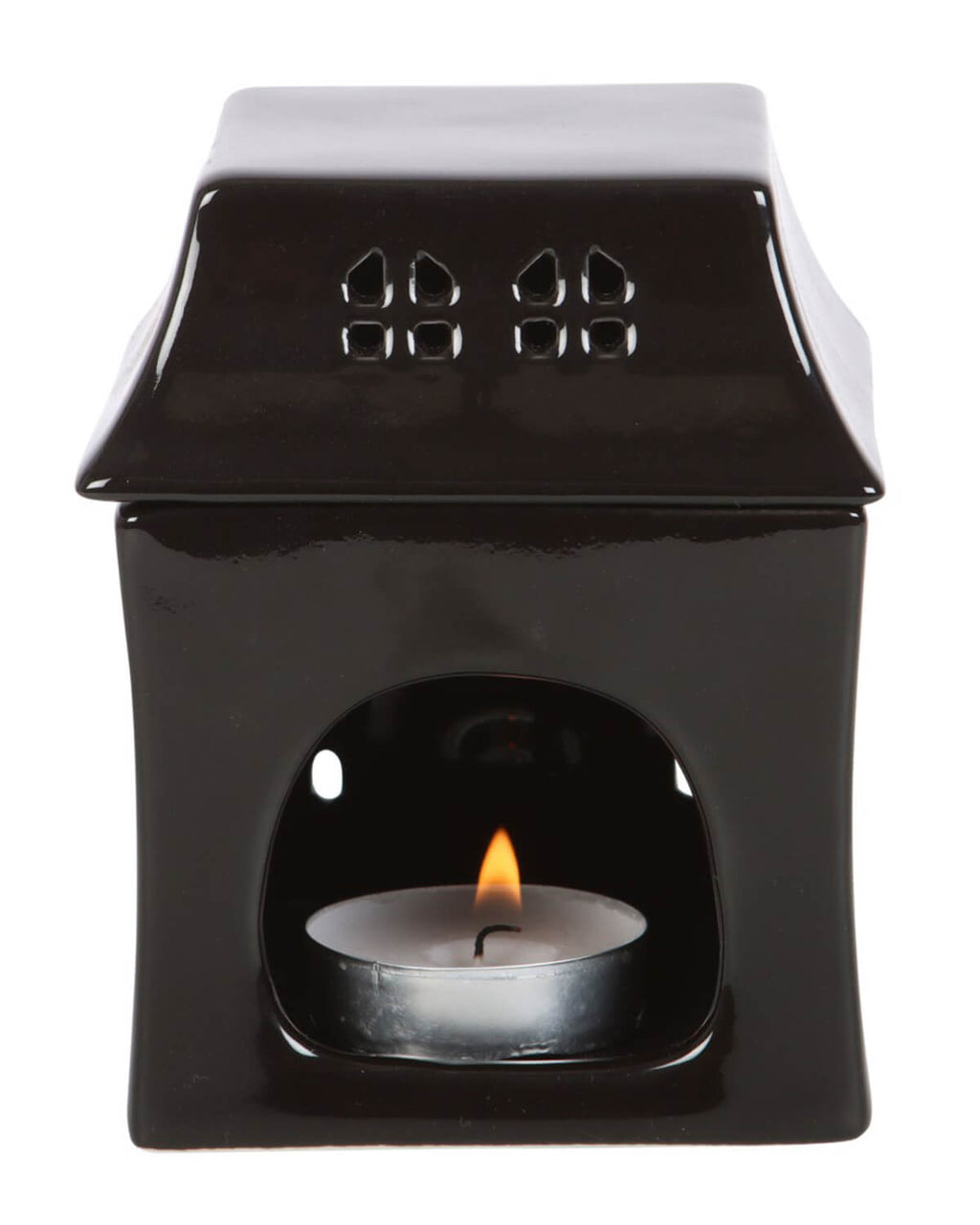 Close-up of the haunted house oil burner showing a tealight candle glowing inside through the arched front opening.