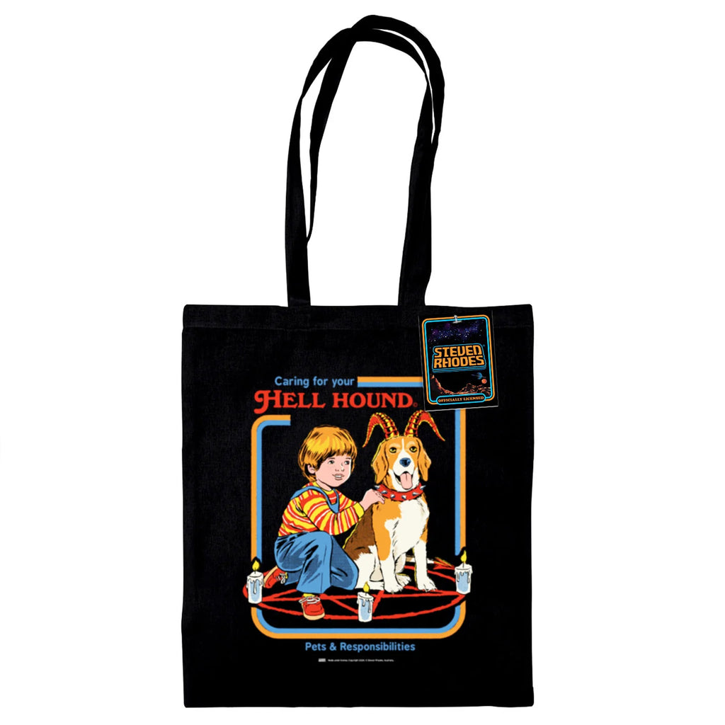 A black tote bag featuring Steven Rhodes’ “Caring for Your Hell Hound” design. The artwork showcases a boy kneeling next to a beagle with red horns, sitting in the middle of a summoning circle surrounded by lit candles. The text reads “Caring for Your Hell Hound” and “Pets & Responsibilities.”
