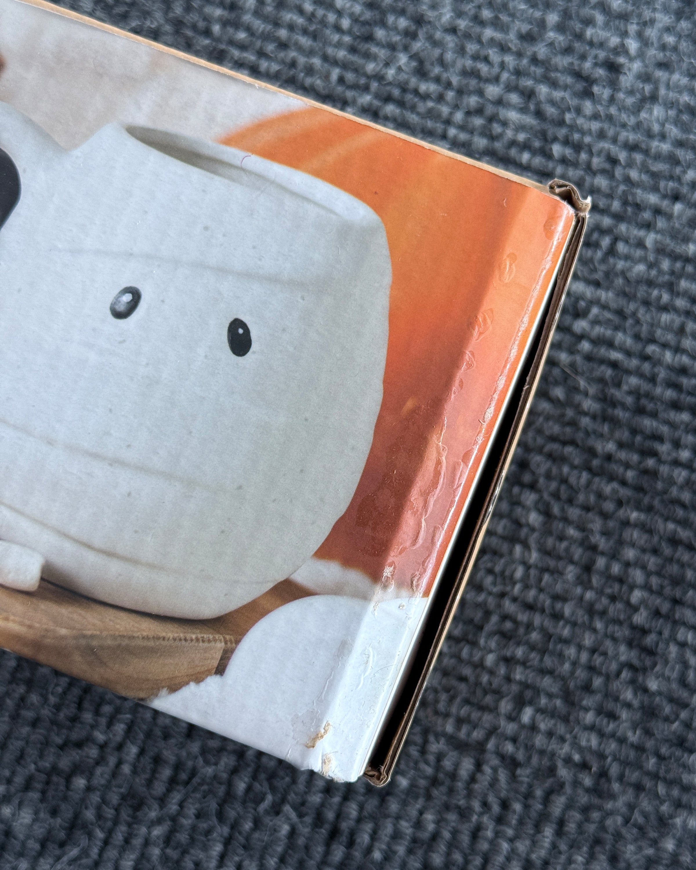 Damaged packaging of Rebel Romance Mummy Shaped Rounded Mug, photographed on a grey textured background. The quirky Halloween mug is shown on the box with a white mummy wrap design, making it a fun gothic homeware gift. Outer box has scuffs and dents, but the spooky alternative mug inside is unaffected.
