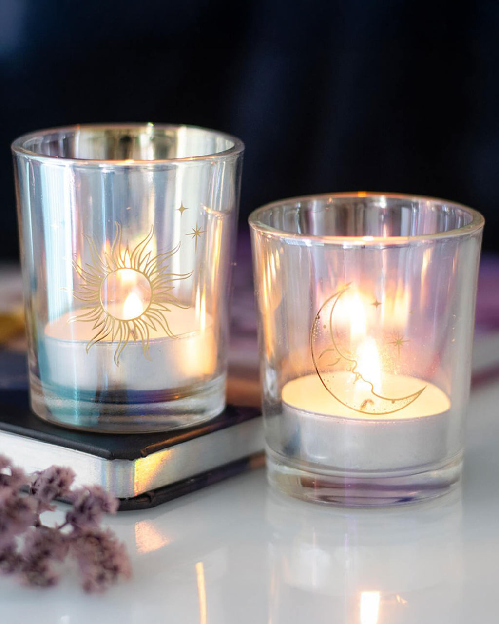 The sun and moon candle holders lit with tealights inside, casting a warm, magical glow.