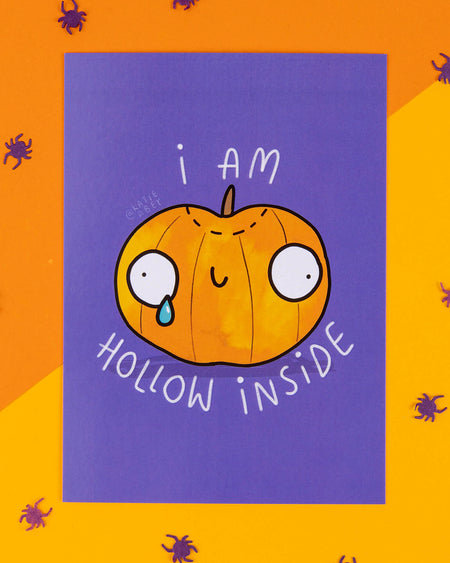A Halloween-themed A6 postcard featuring a cartoon pumpkin with wide eyes and a single tear, with the phrase “I Am Hollow Inside” on a purple background. Designed by Katie Abey, this cheeky and relatable card is ideal for alternative millennials who love spooky humour, quirky stationery, and weirdly wonderful seasonal gifts.