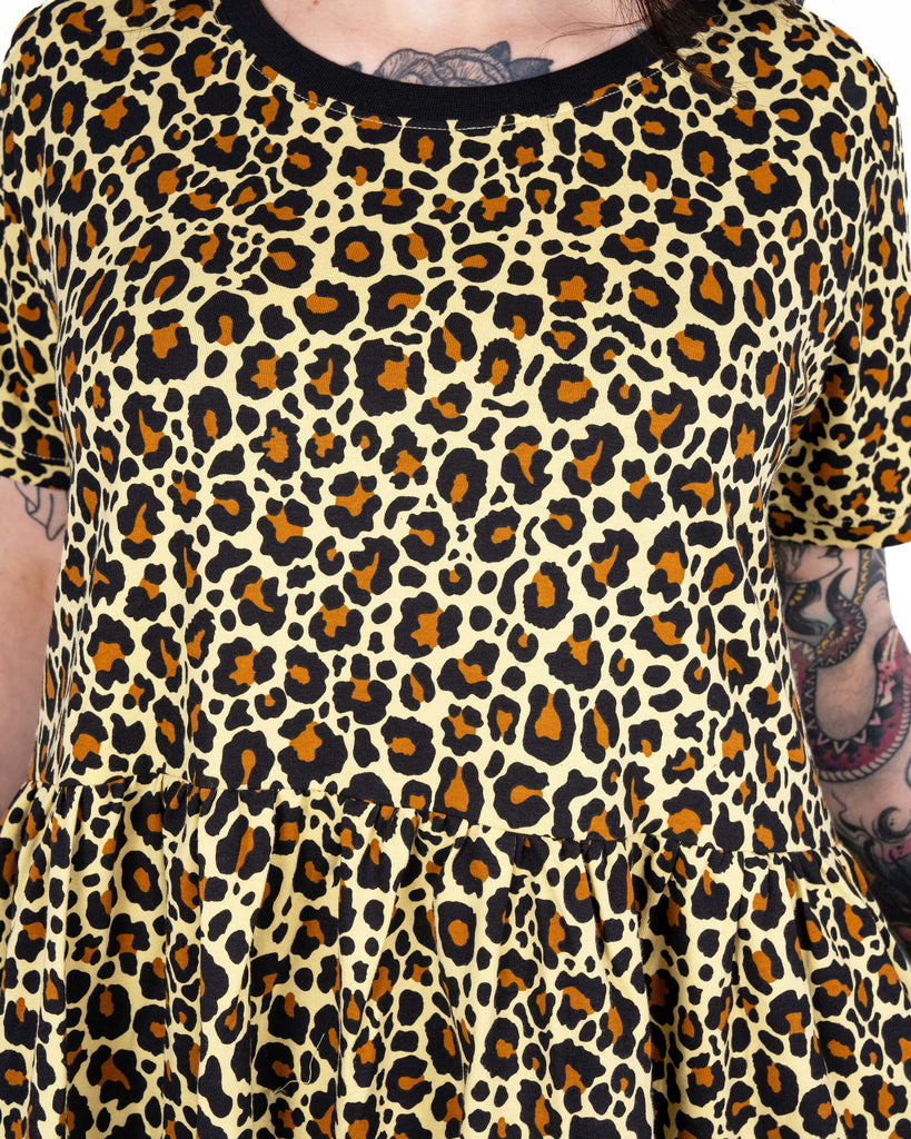 Close-up of the upper front of the Rebel Romance Classic Leopard Print Stretch Smock Dress, showing the black neckline and gathered waist seam.