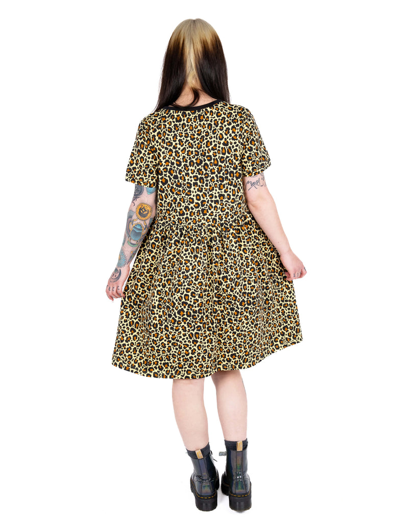 Back view of model Florence wearing the Rebel Romance Classic Leopard Print Stretch Smock Dress to show the relaxed fit and mid-thigh length.