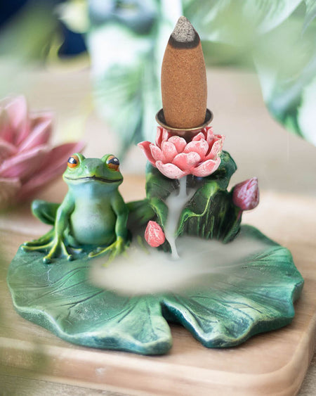Lifestyle shot of the incense burner in use, with backflow incense cone releasing a gentle mist effect cascading down the lily pad.