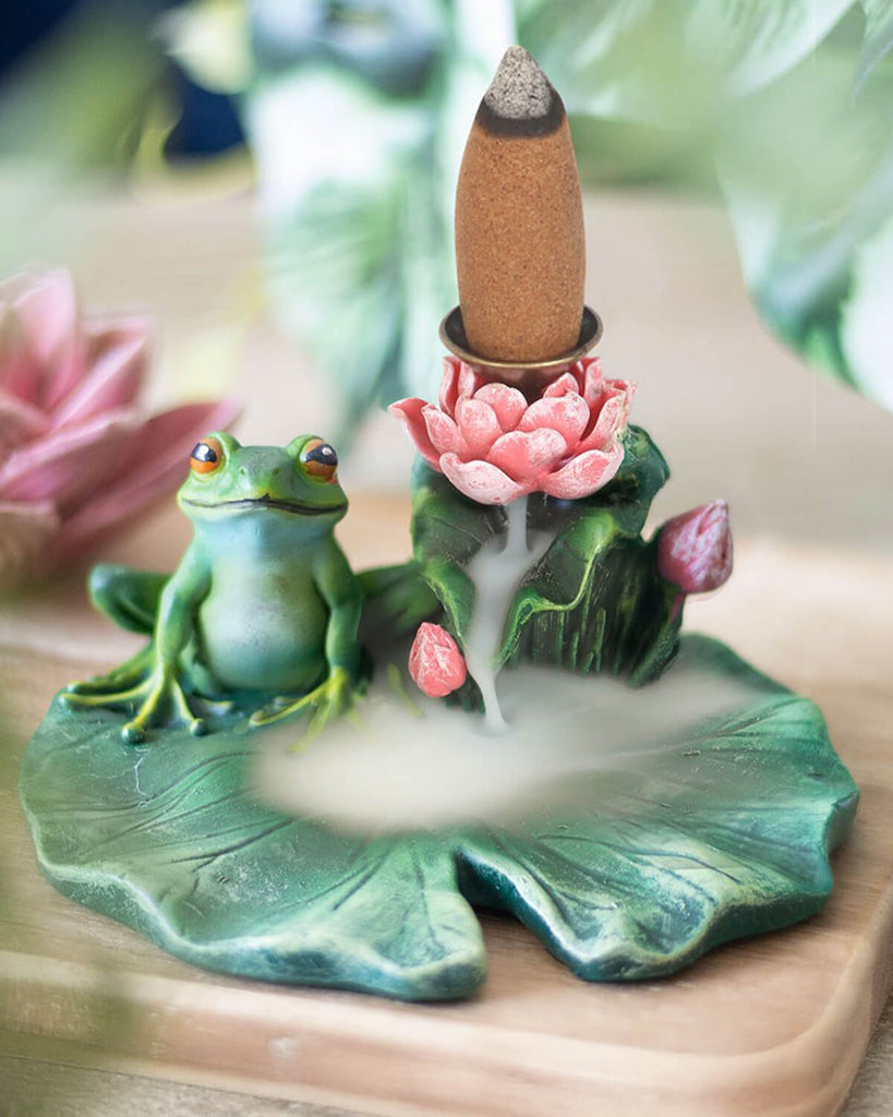 Lifestyle shot of the incense burner in use, with backflow incense cone releasing a gentle mist effect cascading down the lily pad.